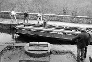 Having been t ransported by water the 1� miles from Cromford, the galvanised sections arrive on our workboat. In the foreground is the completed main bearing assembly on the main concrete base. (The rest was filled later).